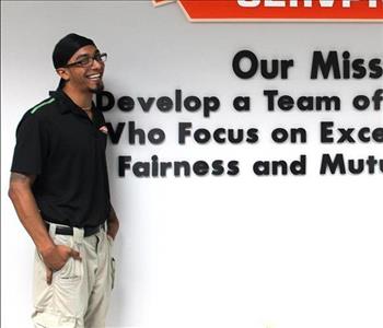 Tech standing in front of our mission statement